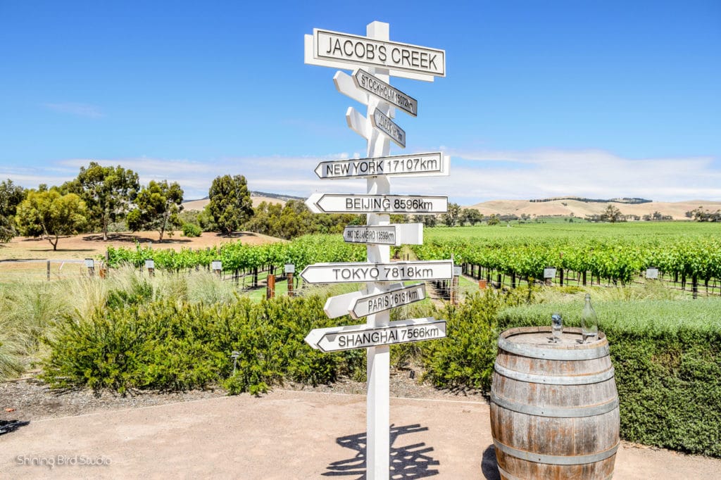 Sign with different cities and distances in the middle of a vineyard in South Australia.