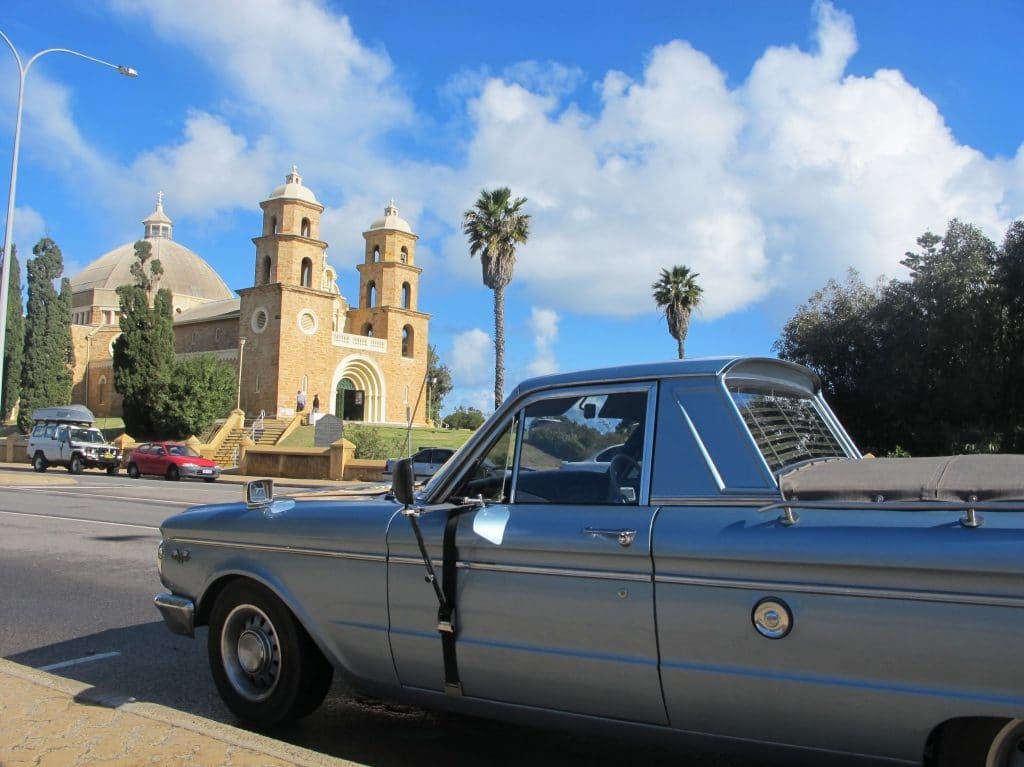 Blue car at the first plan with Geraldton church at the back.